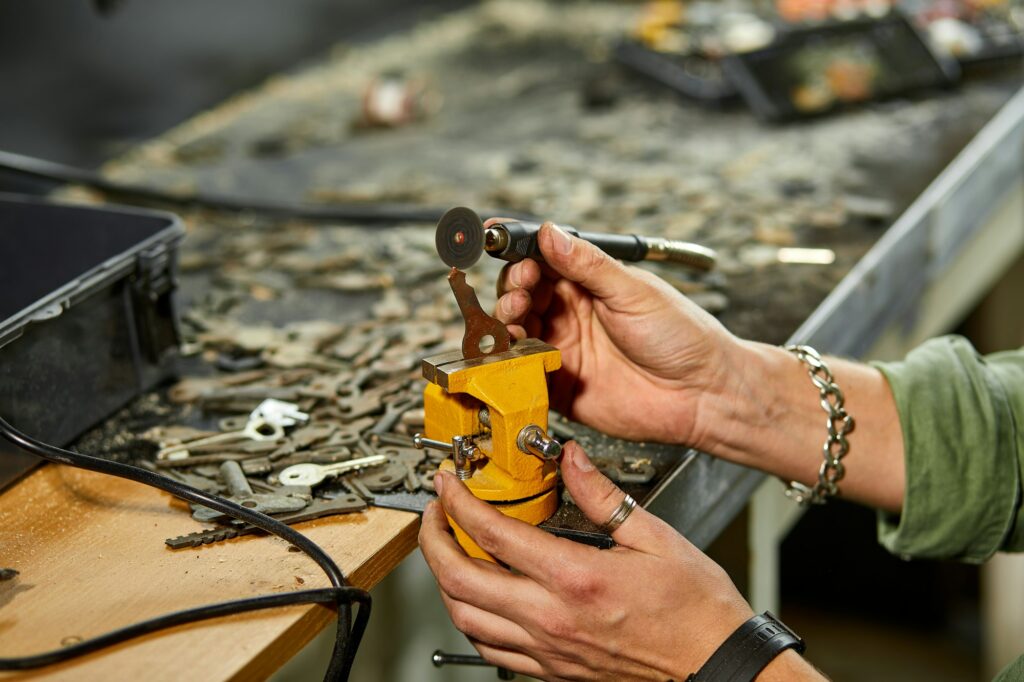 Locksmith in workshop makes new key, use grinding engraving machine